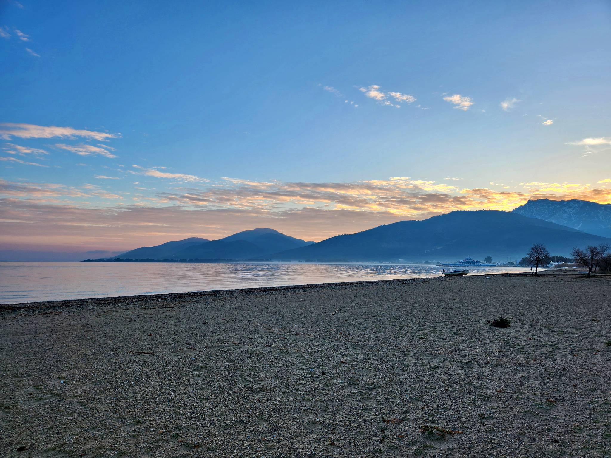 Sunrise over the bay with mountains across the water