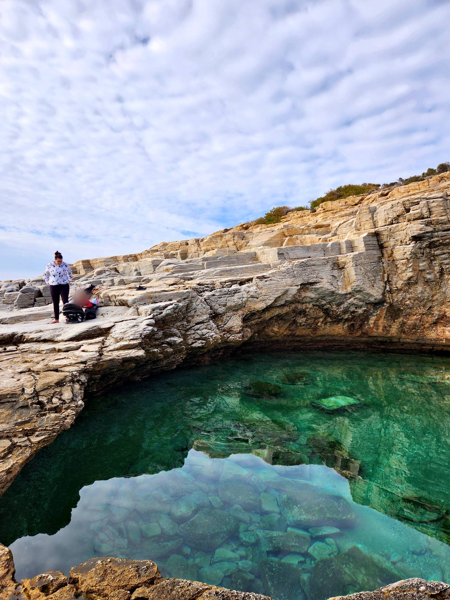 Emerald water in a rock pool cut into the cliffs