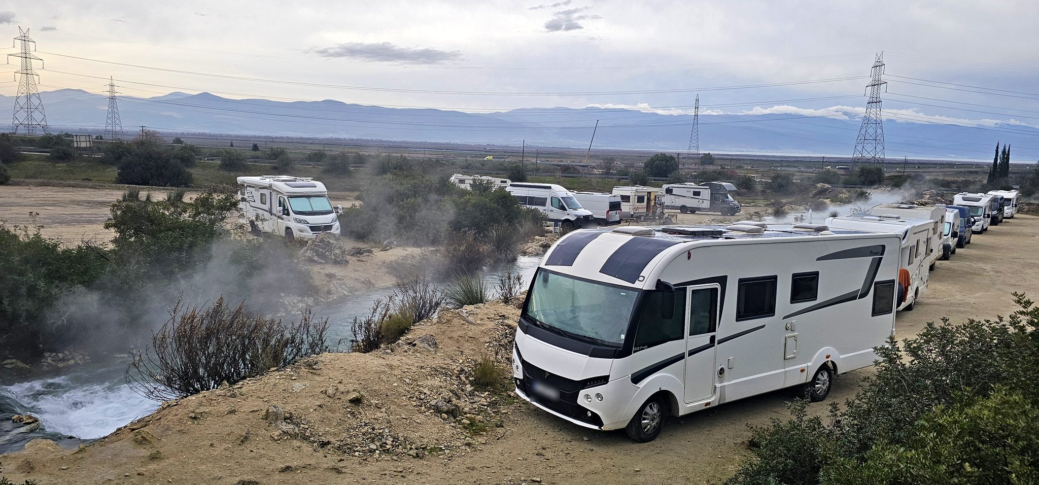 Motorhomes lined up beside the steaming Thermopylae hot springs river