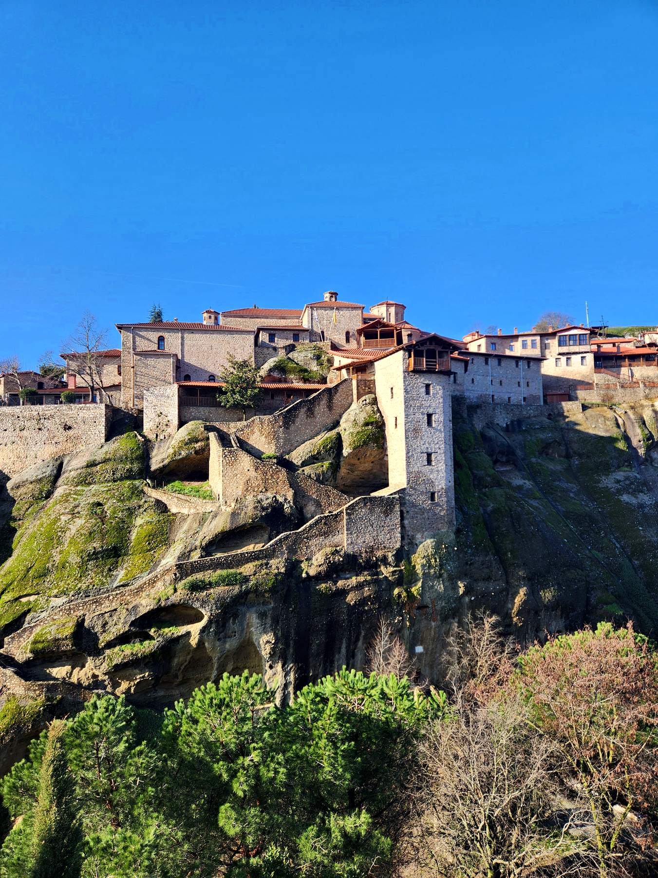 Monastery perched on a rock pillar under blue sky